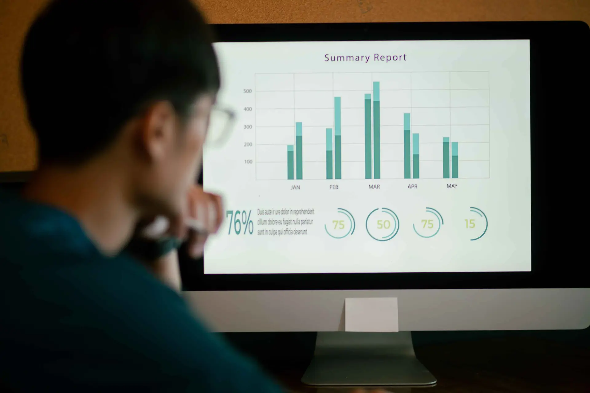 Professional thoughtfully reviewing monthly summary report and performance metrics on screen, reflecting untapped Dynamics 365 F&SCM data potential | Dynamics Monk